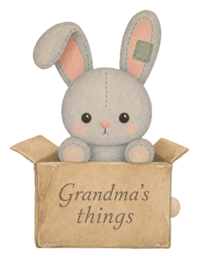 Pip, a well-loved stuffed elephant, peeking out of a cardboard box labelled Grandma's things